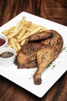 Roast rotisserie half chicken with french fries simple meal on white plate photo