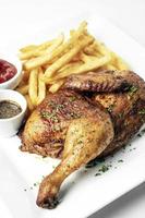 Roast rotisserie half chicken with french fries simple meal on white plate photo