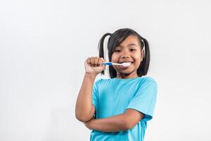 niña cepillándose los dientes en la foto de estudio.
