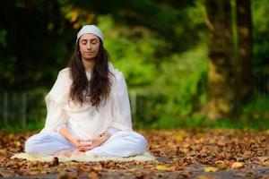 Girl practices yoga among the autumn leaves photo