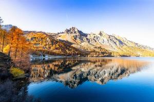 Swiss Alpine landscape with an Engadine lake and mirrored mountain photo