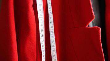 White measuring tape on the background of the red fabric photo
