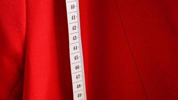 White measuring tape on the background of the red fabric photo