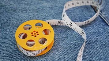 Blue jeans and a measuring tape. Slimming or sewing denim concept