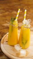 Bottle of orange juice with ice cubes, selective focus photo