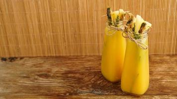 Pineapple juice in a small bottle. Pineapple slices decorate the drink photo