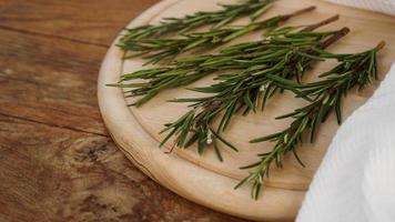 Sprigs of rosemary on a wooden board for cutting. Rustic style photo