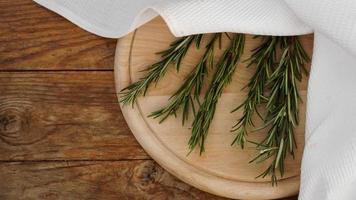 Sprigs of rosemary on a wooden board for cutting. Rustic style photo