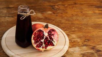 Ripe pomegranates with juice on wooden background. photo