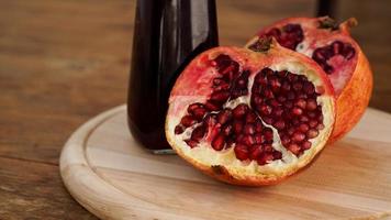 Ripe pomegranates with juice on wooden background. photo