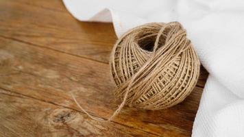 Skeins of jute rope on wooden table flat lay background photo