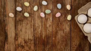 Chicken eggs in a cardboard tray and Easter decor on a wooden photo