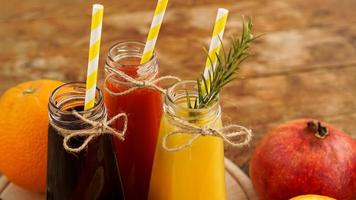 Home made lemonade in little bottles. Multicolored juices and fruits photo