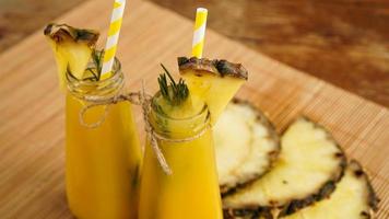 Fresh made Pineapple Juice with Ice in a small glass bottle photo