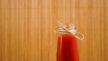 Bottle of tomato juice on wooden background photo