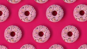 patrón creativo festivo de filas de donas sobre fondo rosa foto