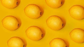 Food pattern with lemons on yellow paper background photo