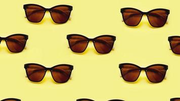 Sunglasses pattern on yellow background with the shadows photo