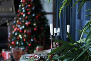 Metal candlestick with a white candle against the festive background photo