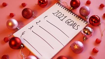 lista de objetivos para 2021. fondo rosa con bolas de navidad foto