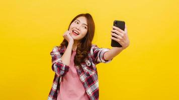 mujer asiática haciendo foto selfie en teléfono con expresión positiva.