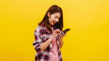 Asian female using phone with positive expression, smiles broadly. photo