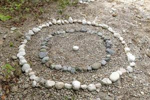 Circles of white and gray pebbles on the bank of a stream photo