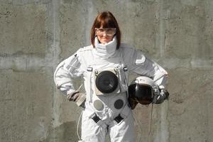 Mujer astronauta sin casco en el fondo de una pared gris foto