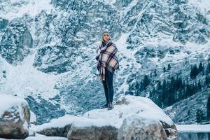 Woman in a poncho in the mountains in winter, adventure and travel photo