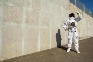 Mujer astronauta sin casco en el fondo de una pared gris foto