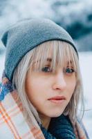 Portrait of girl in a hat with a scarf in the mountains in winter photo