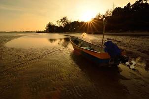 Boat near the beach when the sun goes down photo