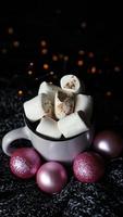 Christmas hot chocolate with marshmallows on a table with lights bokeh photo