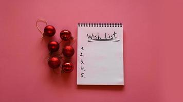 Notebook on pink background with christmas balls photo