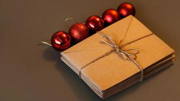 composición navideña. sobres artesanales y bolas rojas. pila de cartas foto
