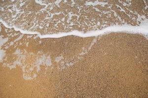 suave ola del mar en la playa de arena, fondo foto