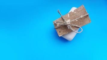 Handmade soap wrapped with twine on a blue clean background photo