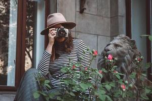 Beautiful woman in hat takes a photo old fashioned camera