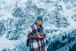 Girl with old vintage camera on a background of snow mountains