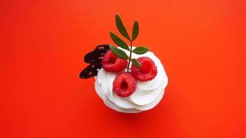 Sweet dessert, cupcake with butter cream and raspberry photo