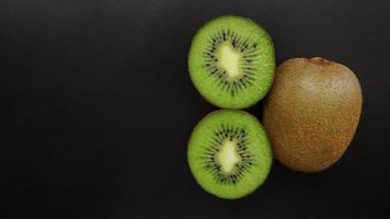 Jugosa fruta de kiwi sobre un fondo negro, vista superior, espacio de copia foto
