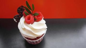 Delicious raspberry cupcakes on dark background photo