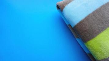 Soft blue blanket on blue background. Autumn comfort photo