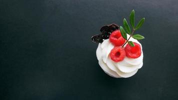 Delicious raspberry cupcakes on dark background photo