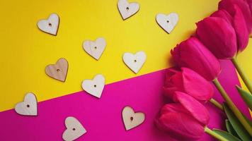 Pink tulips with hearts on the pink background. Flat lay, top view. photo