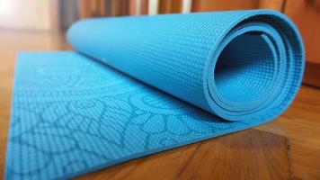 Close up of yoga, fitness floor mat at home in a roll. Healthy concept photo