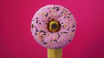 Sweet donut and banana on pink color background. Erotic concept