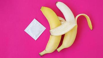 Condoms and two bananas together, concept of contraceptives photo