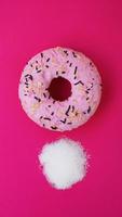 Doughnut with sugar on pink background. Sweet donuts. photo