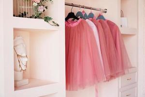 Dressing closet with pink clothes on hanger photo